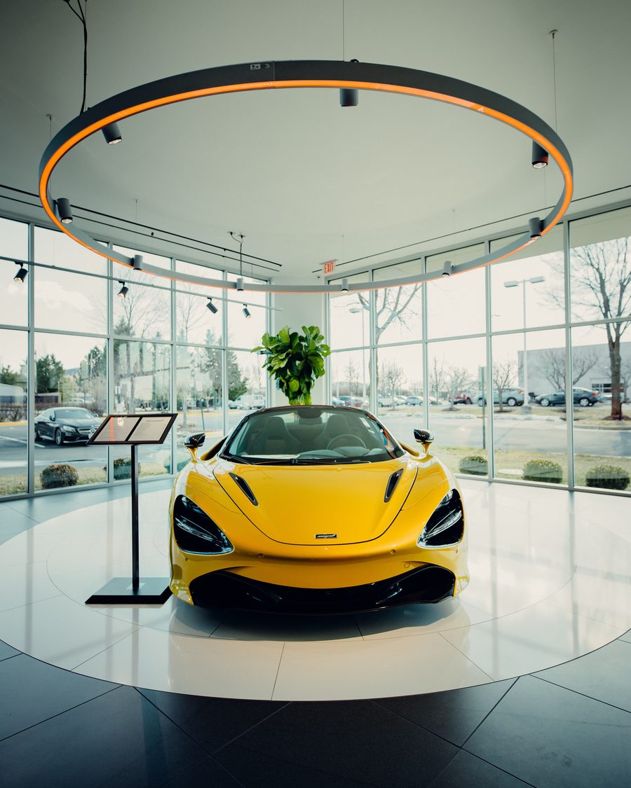 A car on a turntable in a glass showroom