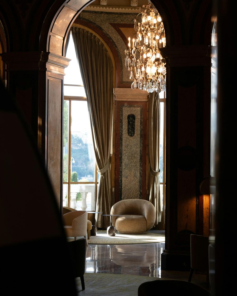 A palazzo salon with a chandelier and tall curtained windows